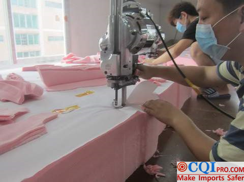 Workers use machines to cut fabrics in pajamas factories.